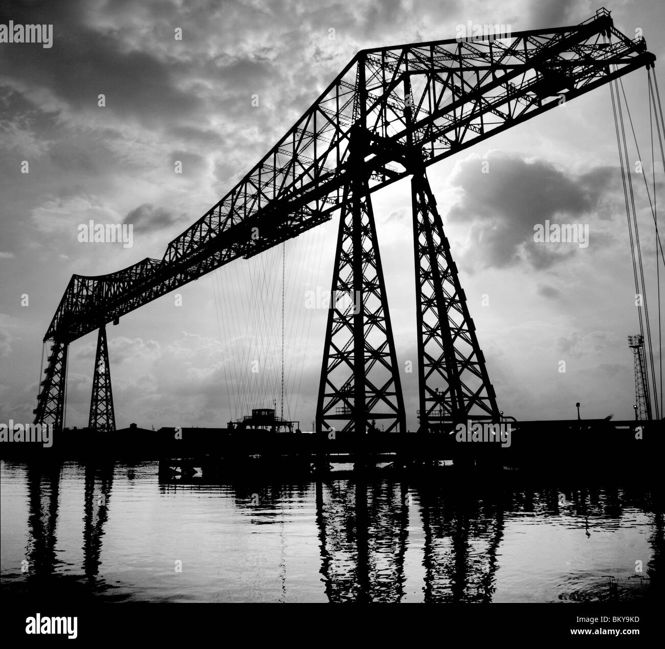 Transporter Bridge on river Tees in Middlesbrough with sun behind back lit silhouette atmospheric black & white with reflection Stock Photo