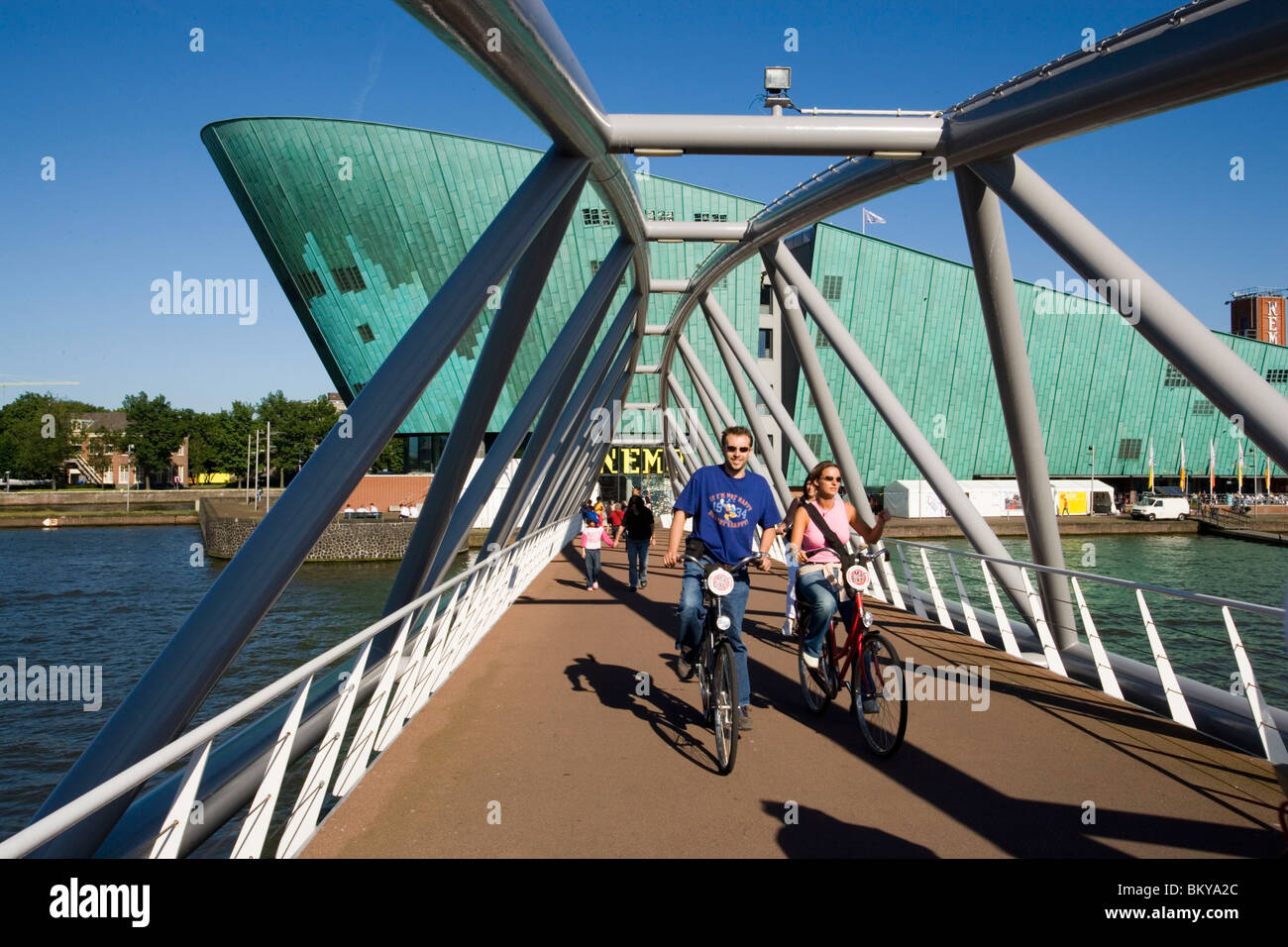 NEMO Museum, Bridge, Cyclists, Cyclists on bridge, leaving NEMO Museum, Amsterdam, Holland, Netherlands Stock Photo