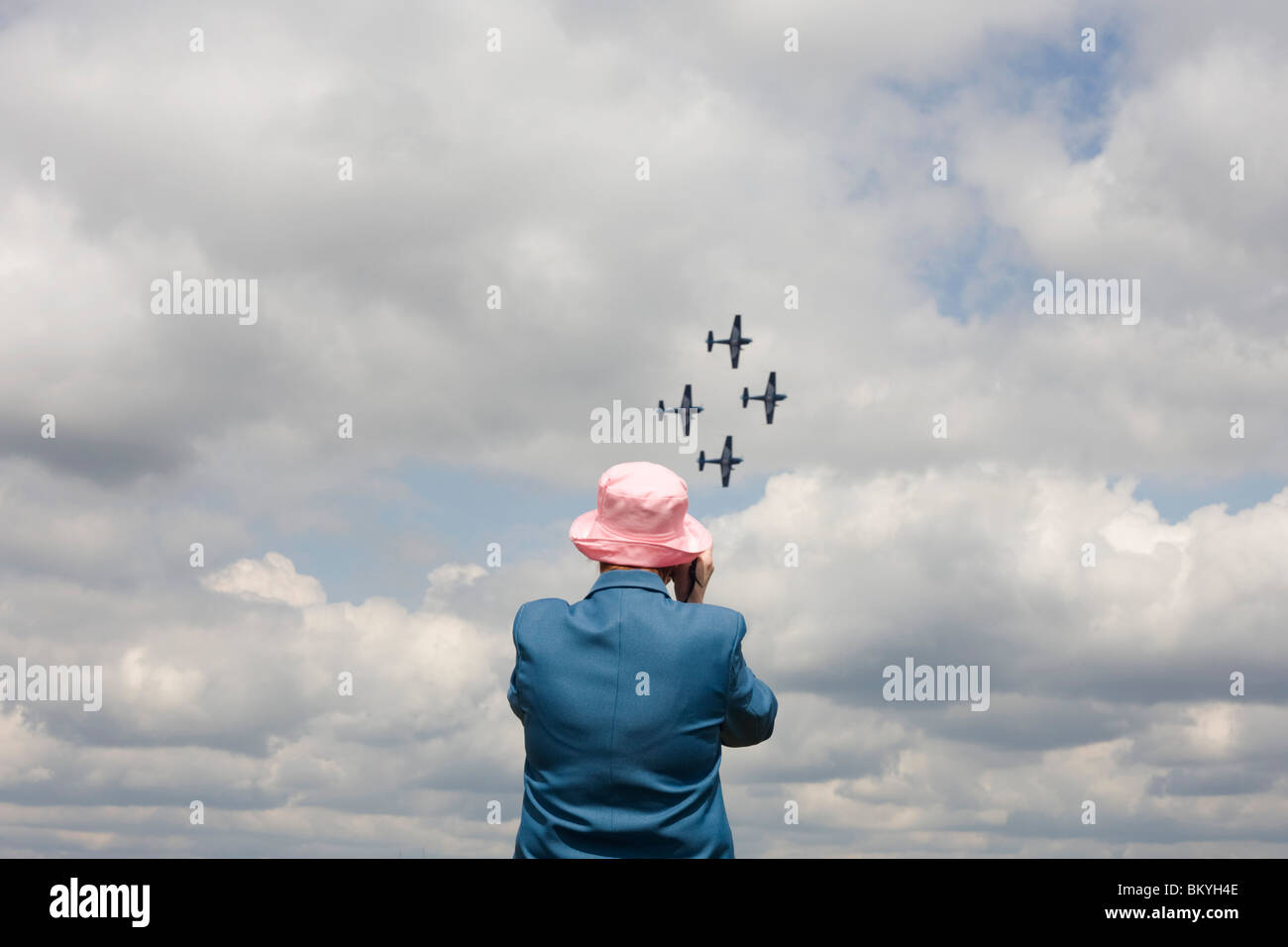 Lady plane spotter watches fly-past of the Blades aerobatic Team at Farnborough 2010 launch. Stock Photo