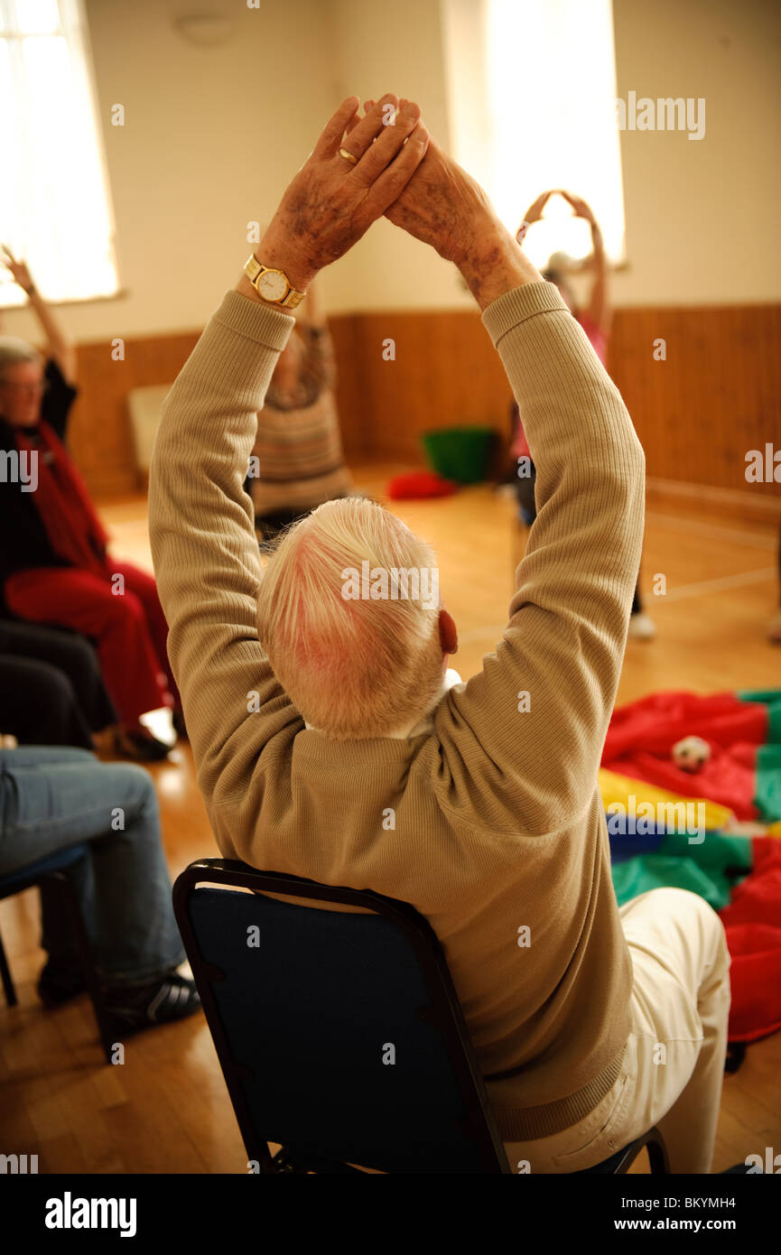 rear view of senior citizens participating in a low-impact chair aerobics  class in a small village hall in west wales UK Stock Photo - Alamy