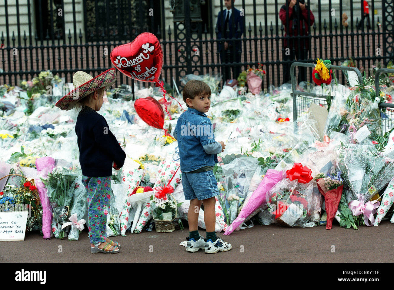 CHILDREN LAY FLOWERS FOR DIANA OUTSIDE BUCKINGHAM PALACE 14 September