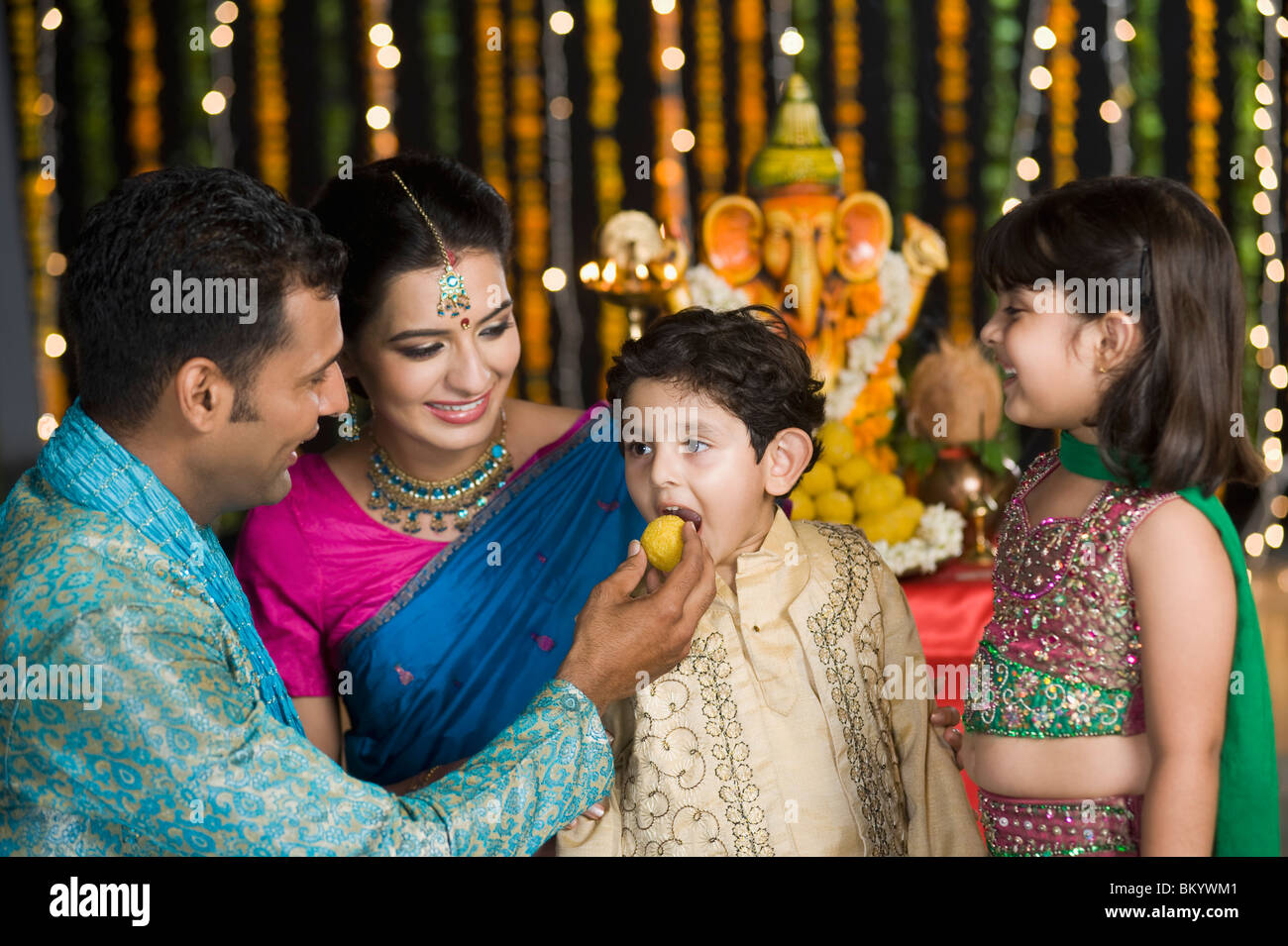 Man feeding sweets to his children on Diwali Stock Photo