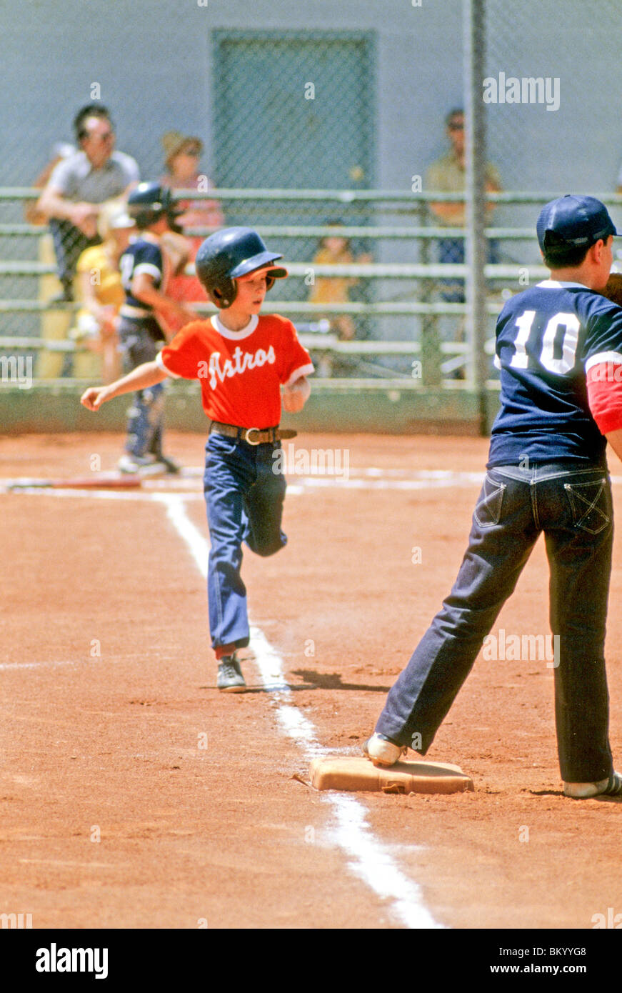 Little league baseball batter runs to first base after making a hit
