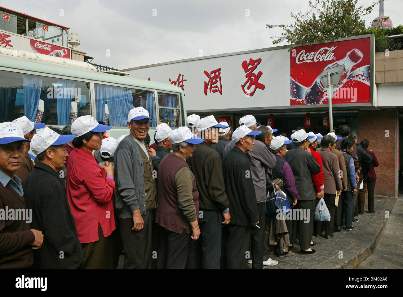 chinese tourists, bus tour, uniform cap, advertising, queue, old folks Stock Photo