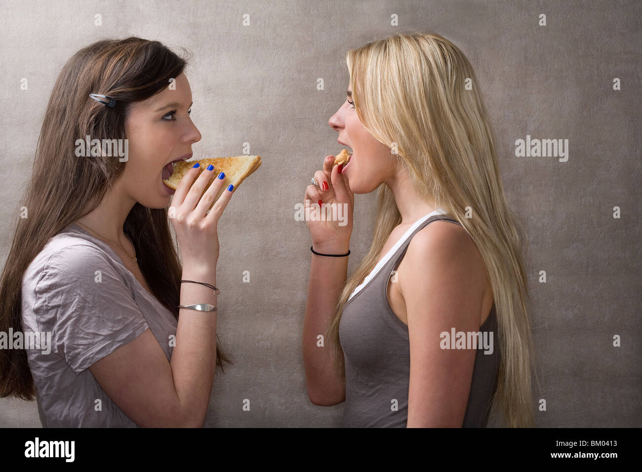 Teen girls eat sandwiches Stock Photo
