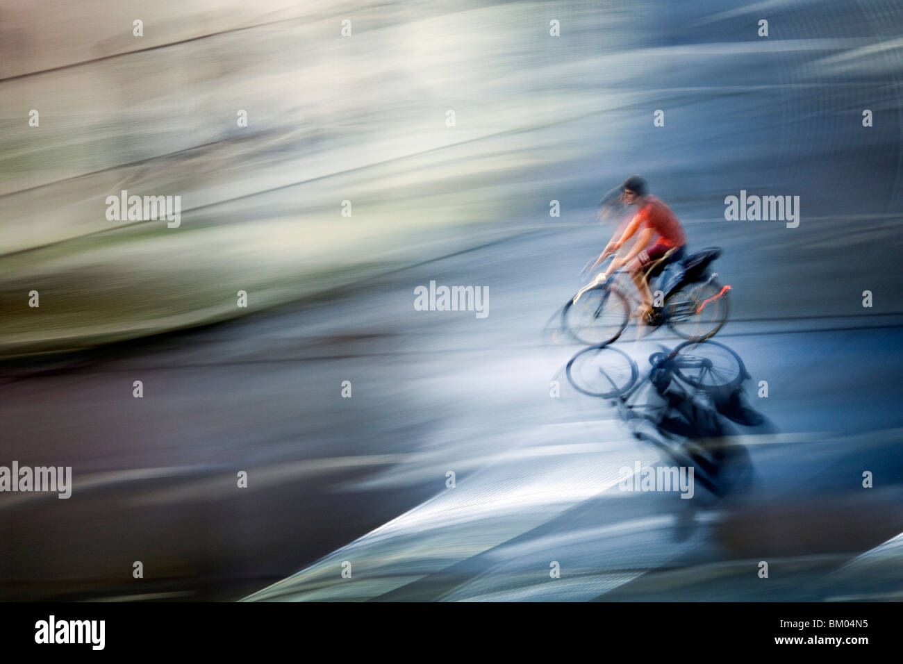 Panning shot of a cyclist by night, Berlin, Germany Stock Photo