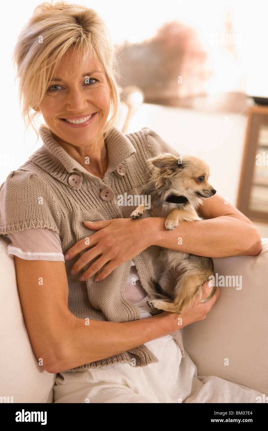 Woman holding a little dog in her arms Stock Photo Alamy