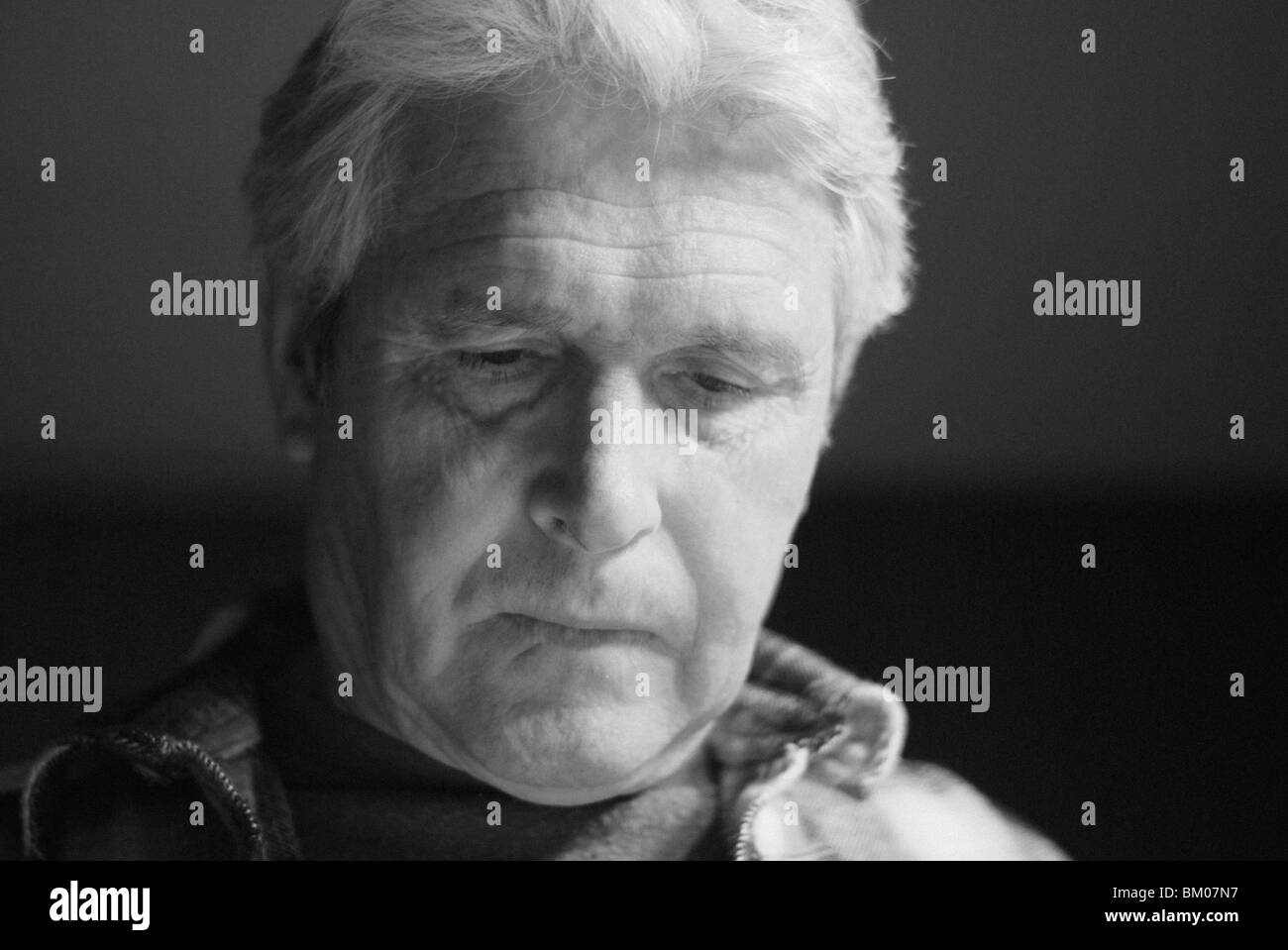 a pensive senior man concentrates while working, a portrait in black and white, suburban albuquerque, new mexico, usa Stock Photo