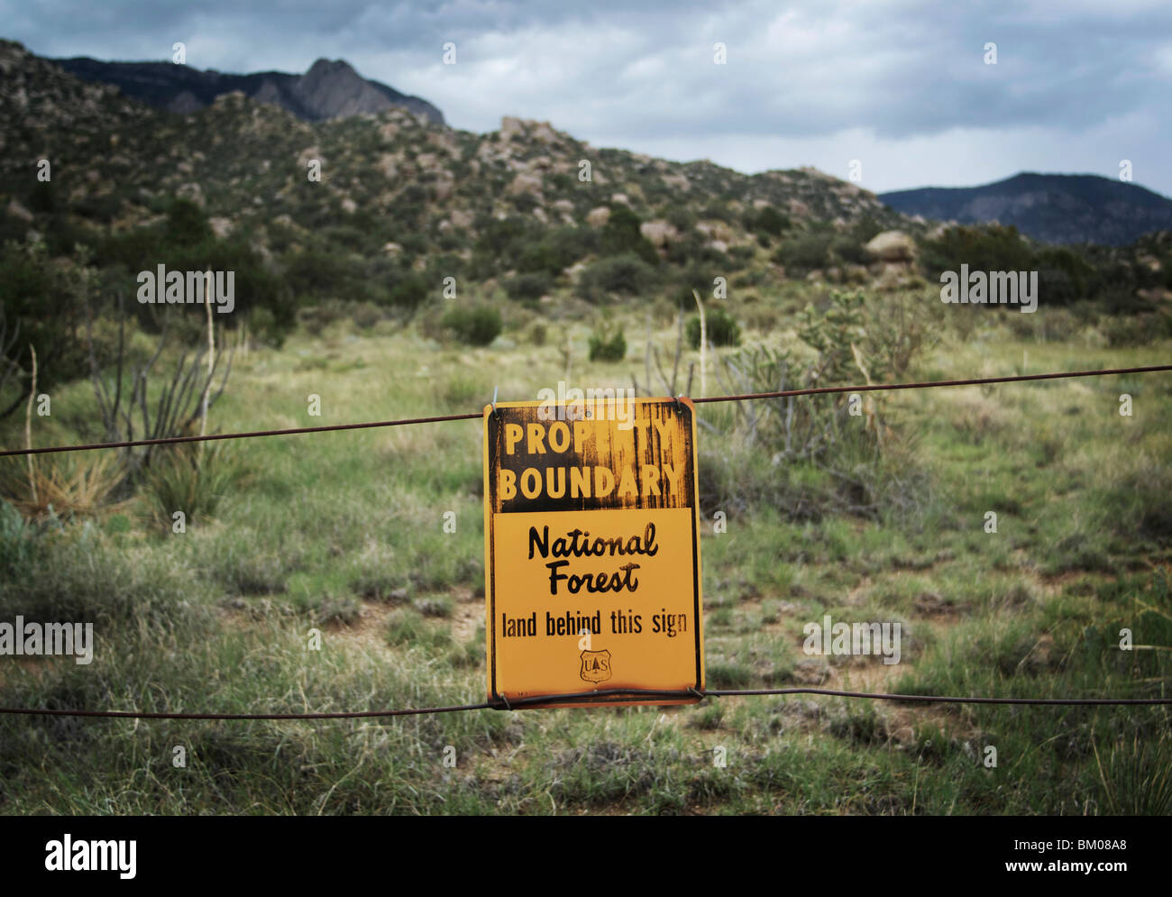 Fence sign marks boundary between public land and national forest elena gallegos park open space of sandia mountains albuquerque Stock Photo