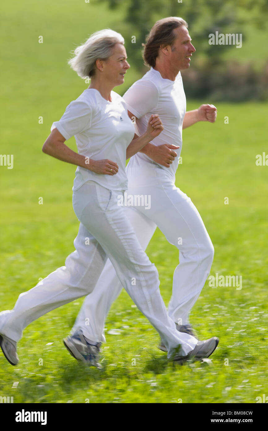 Couple running in field Stock Photo - Alamy