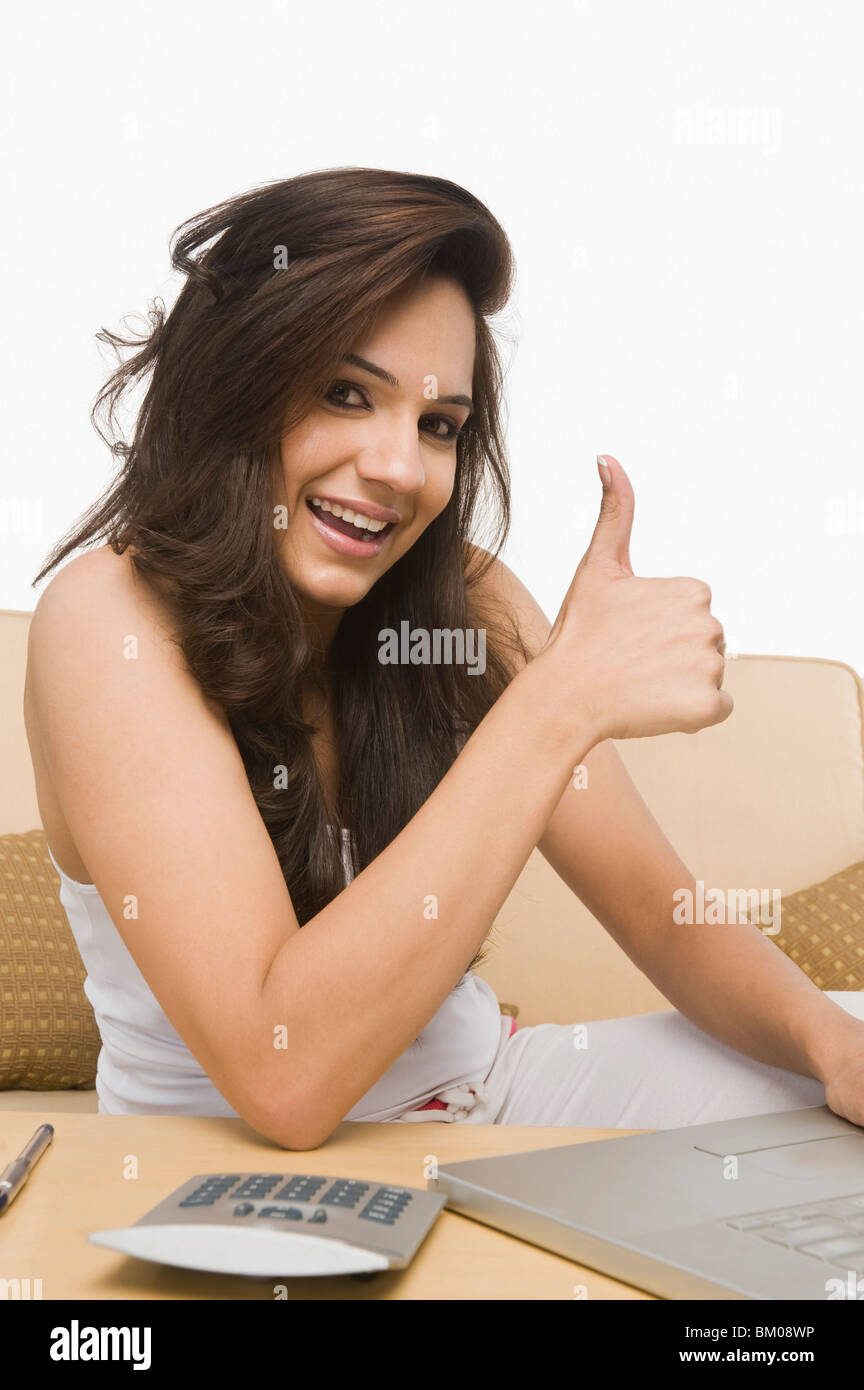 Using a laptop and showing a thumbs up sign hi-res stock photography ...