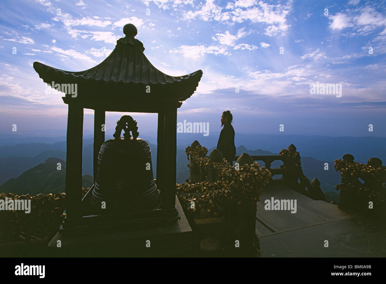 monk meditating in lotus position, sunrise, Golden Hall, Jindian Gong, peak 1613 metres high, Wudang Shan, Taoist mountain, Hube Stock Photo