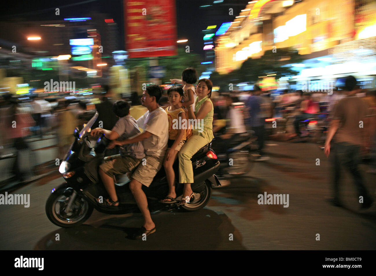 Family with children driving a scooter during the Tet festival at night, Saigon Ho Chi Minh City, Vietnam, Asia Stock Photo
