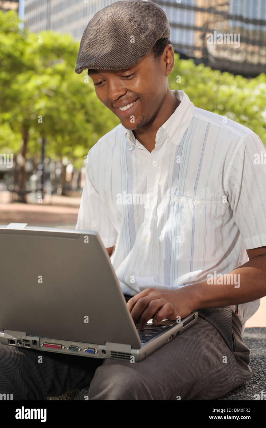 Young man with laptop, Cape Town, Western Cape Province, South Africa Stock Photo
