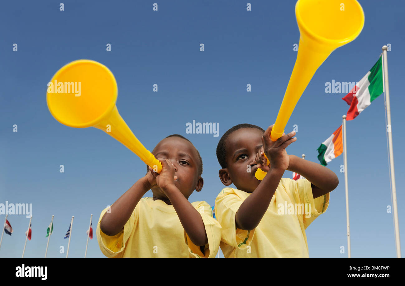 Two boys (2-3) with yellow vuvuzellas, Cape Town, Western Cape Province, South Africa Stock Photo