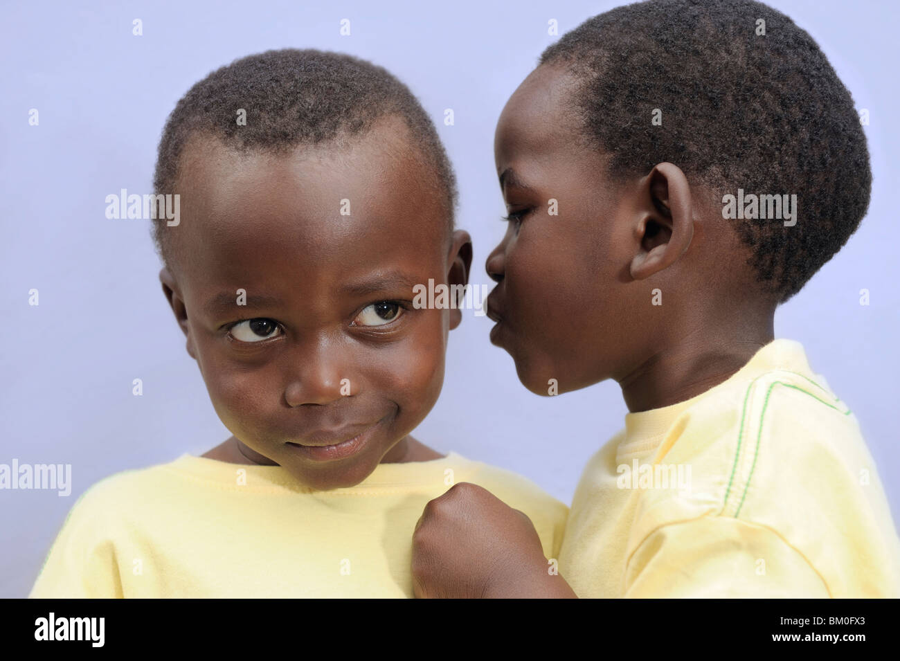 Boy (2-3) whispering into twin brother's ear, Cape Town, Western Cape Province, South Africa Stock Photo