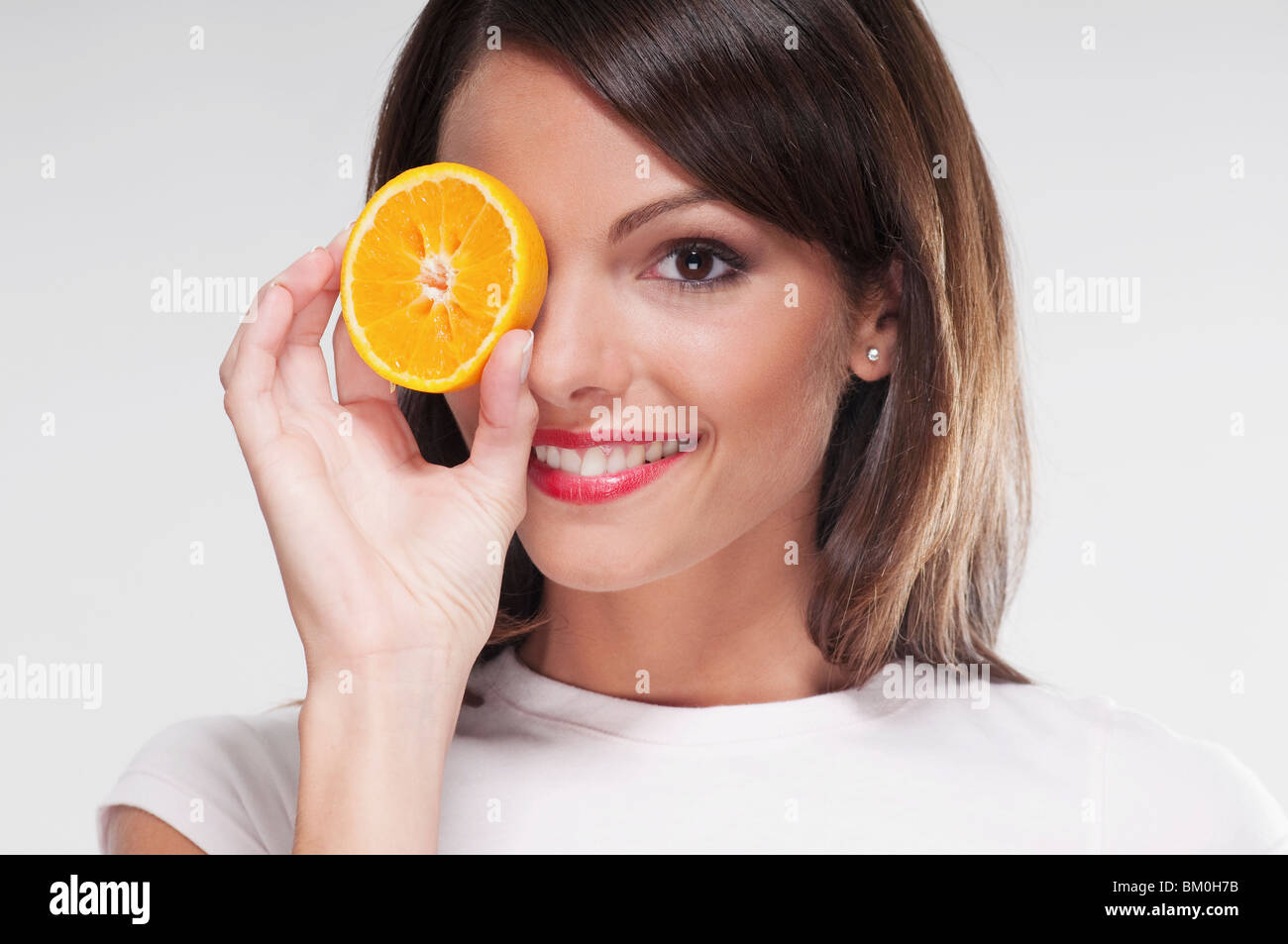 Human hand holding half orange hi-res stock photography and images - Alamy