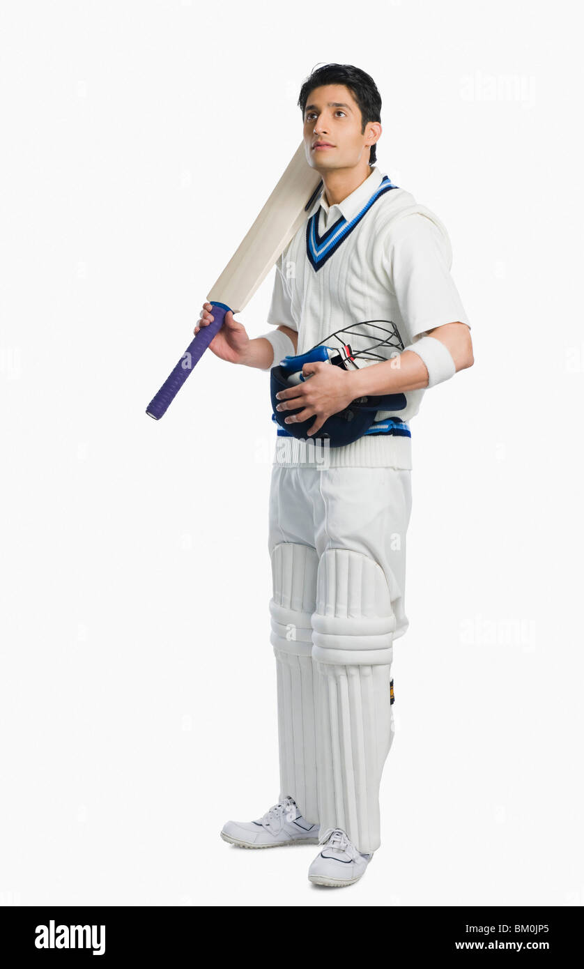 Cricket batsman holding a bat and a helmet Stock Photo Alamy