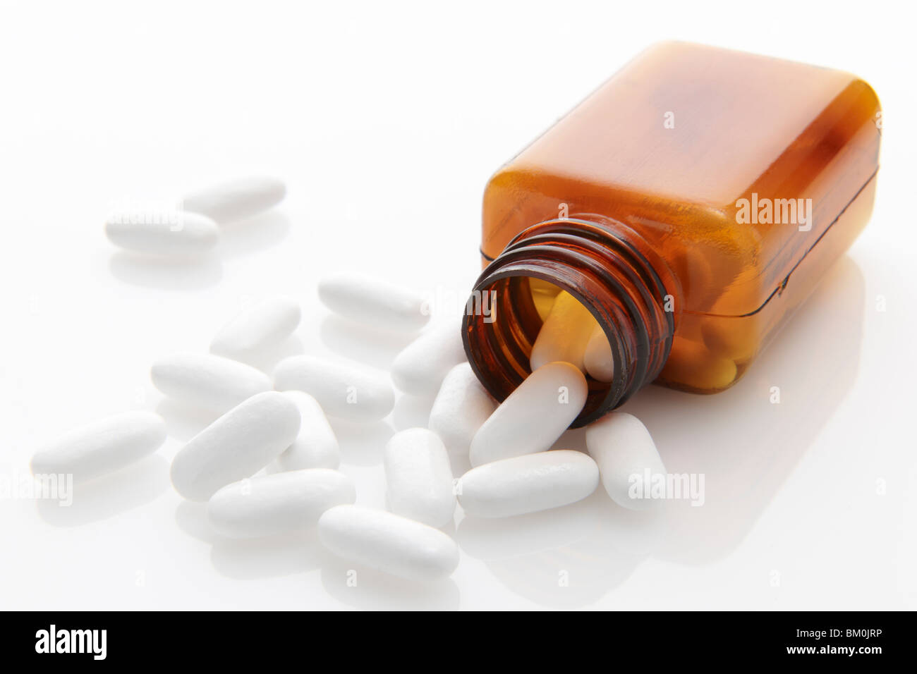 pills spilling out of bottle on white background with space for copy Stock Photo