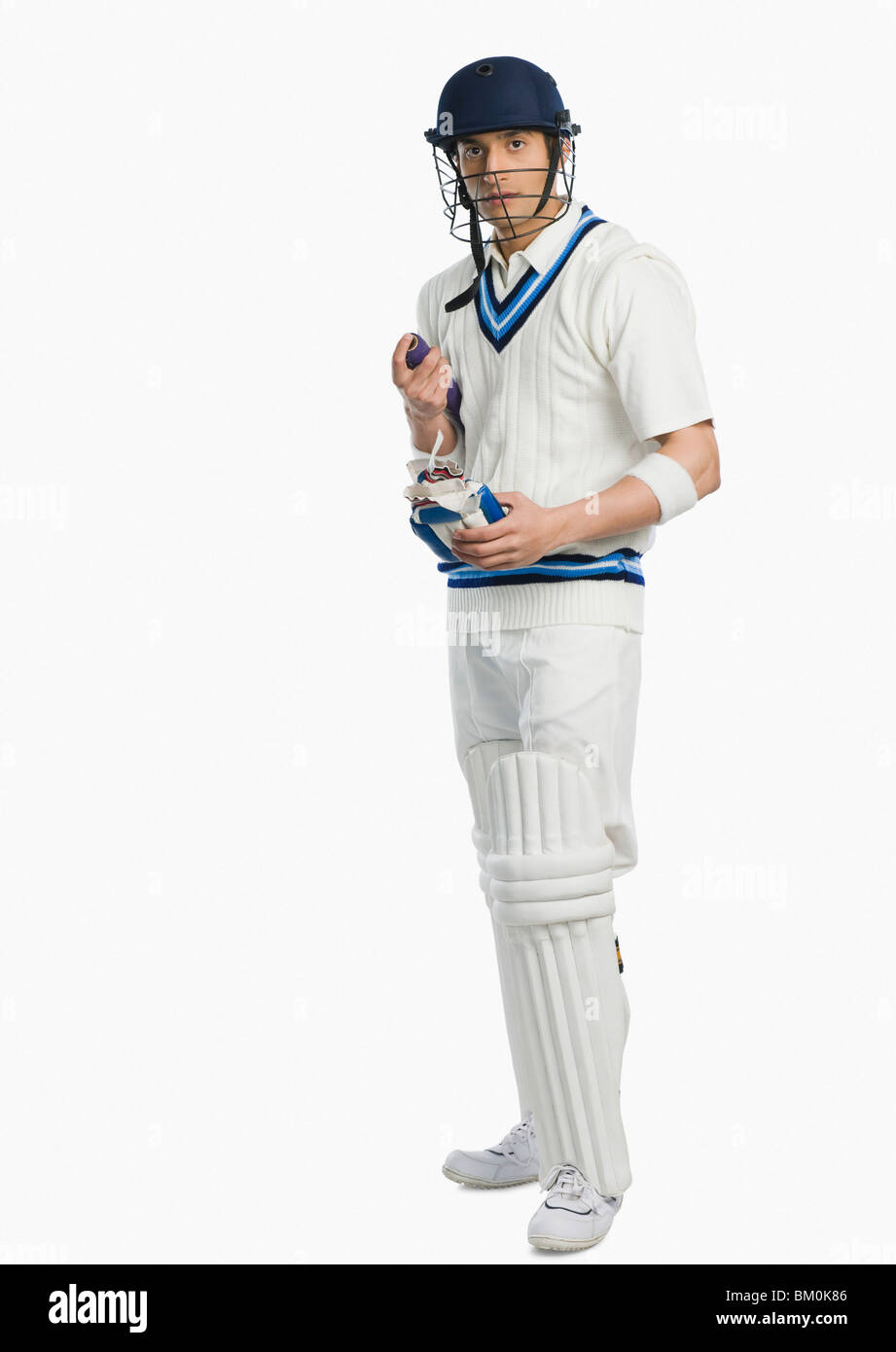 Cricket batsman holding a bat and a glove Stock Photo Alamy