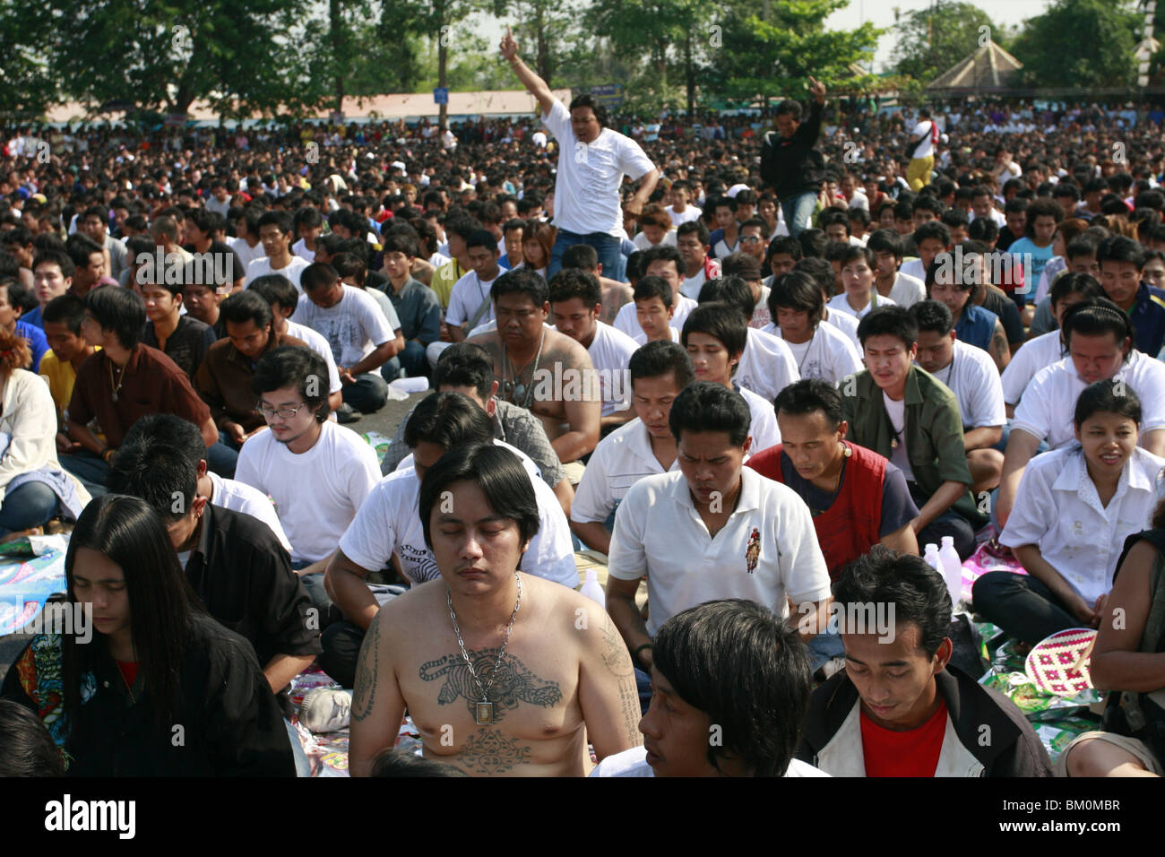 A man in prayer during Wai Kru Day at Wat Bang Phra, a Buddhist temple in Thailand where monks tattoo devotees. Stock Photo