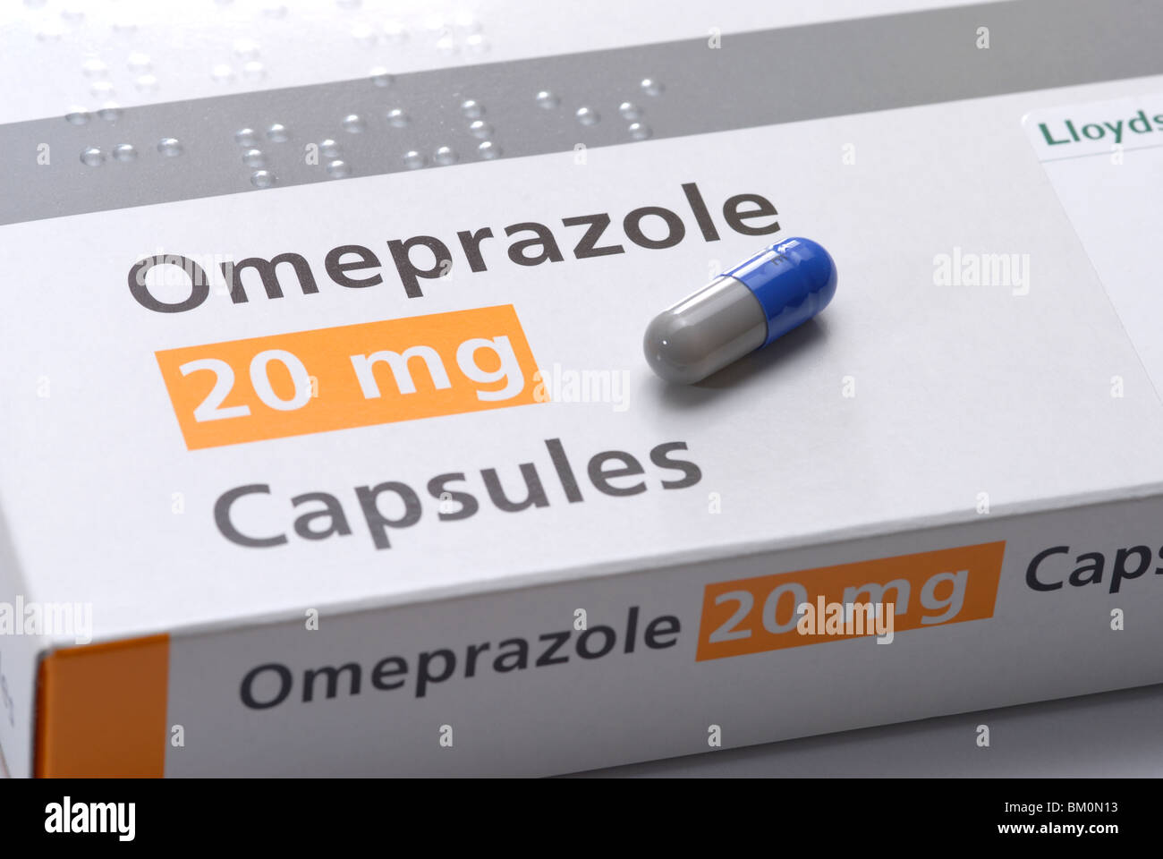 generic image of capsule, box and packet of Omeprazole gastro resistant capsules for treating heartburn and stomach acid Stock Photo