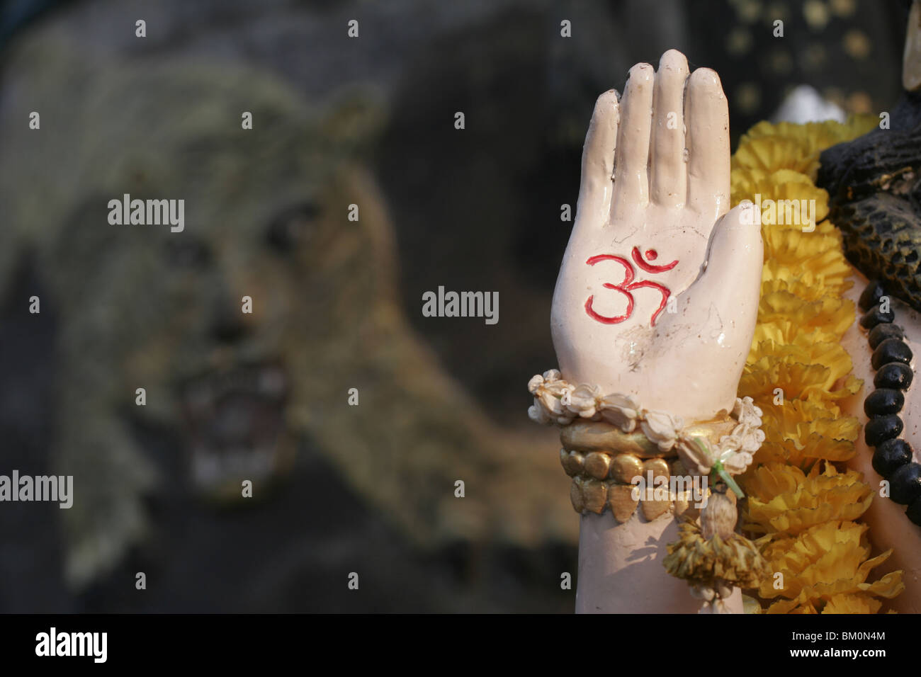 Shiva's hand in front of tiger at Wat Bang Phra, a Buddhist temple in Thailand where monks tattoo devotees. Stock Photo