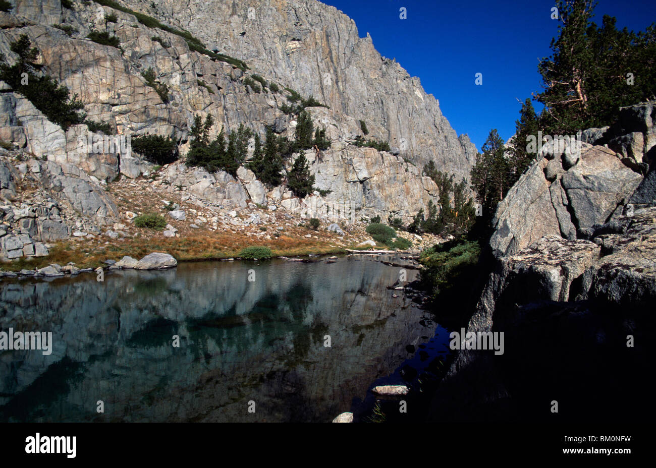Reflection of cliff in a lake, Finger Lakes, John Muir Wilderness, California, USA Stock Photo