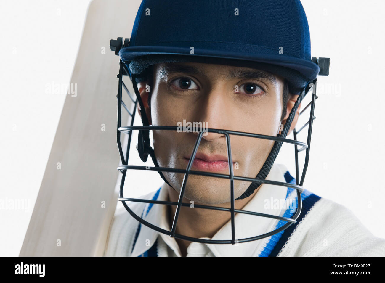 Portrait of a cricket batsman holding a bat Stock Photo