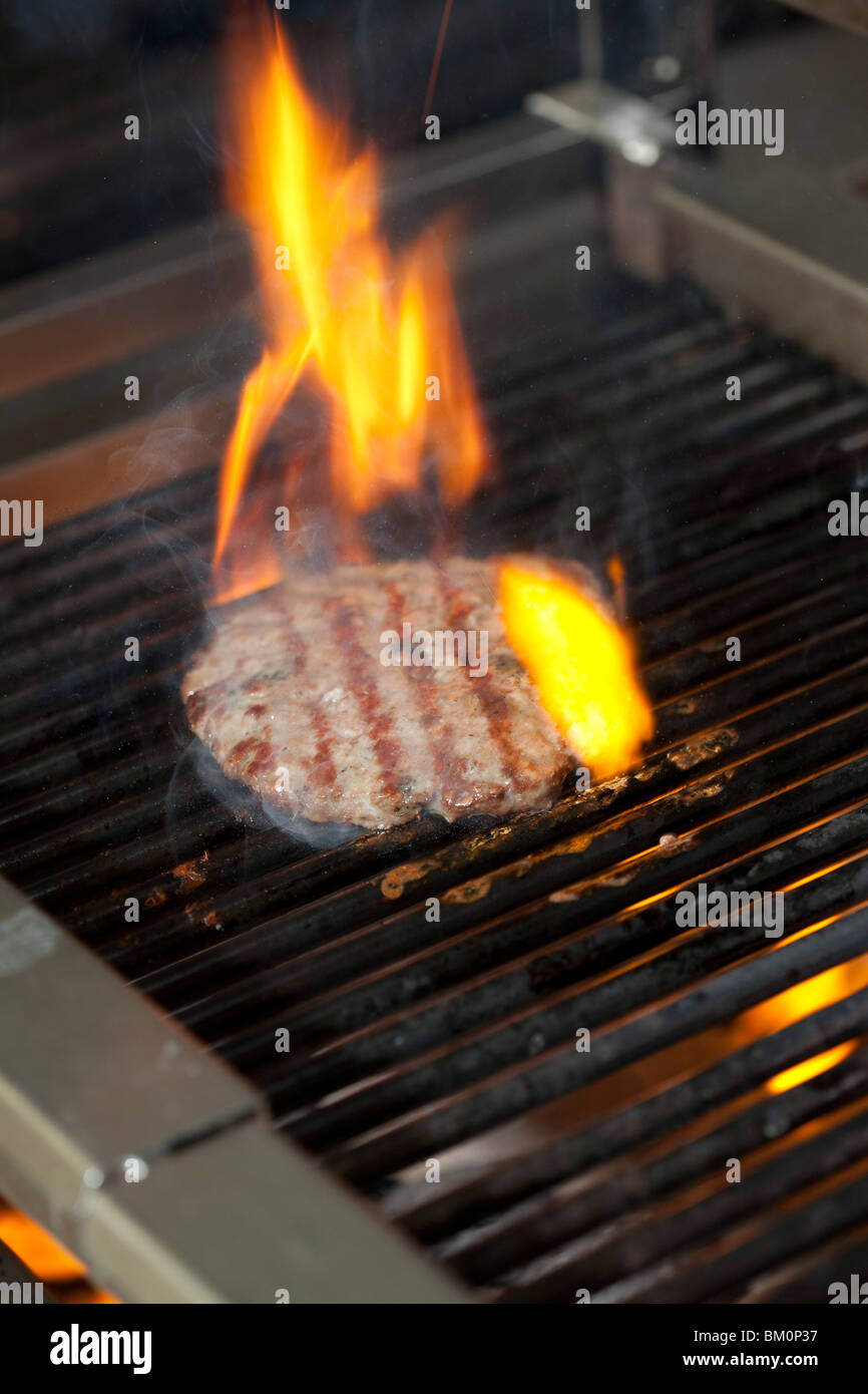 Cooking a flamed beef burger on a grill Stock Photo - Alamy