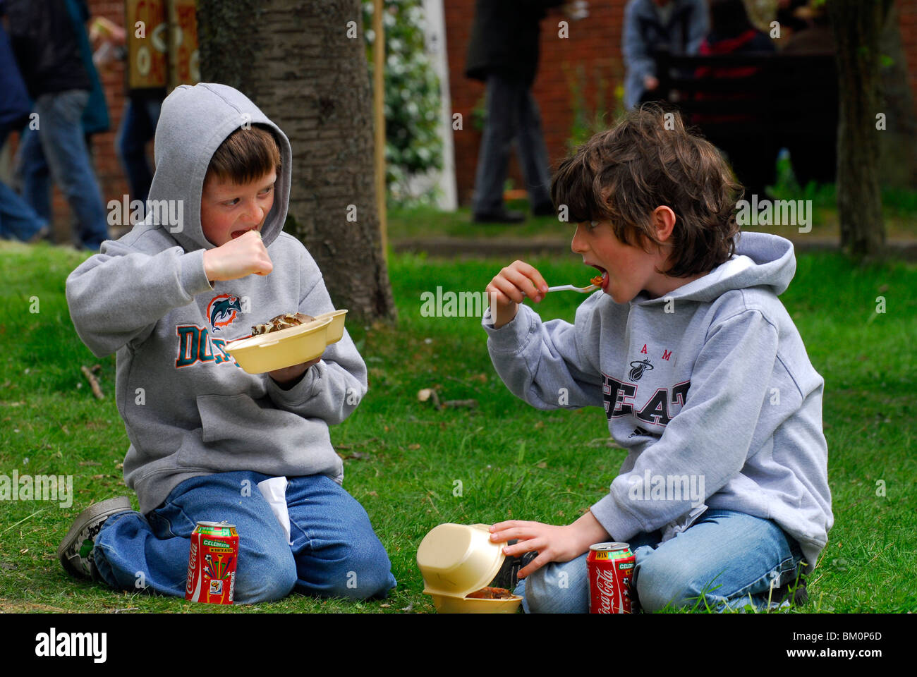 Two youngsters eating healthy food at a sustainability centre open day, East Meon, Hampshire, UK. Stock Photo