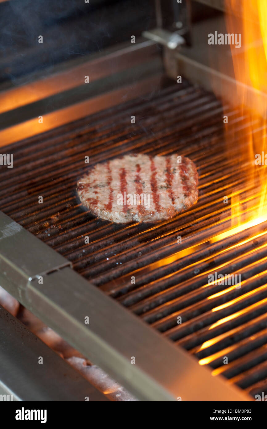 Cooking a flamed beef burger on a grill Stock Photo - Alamy