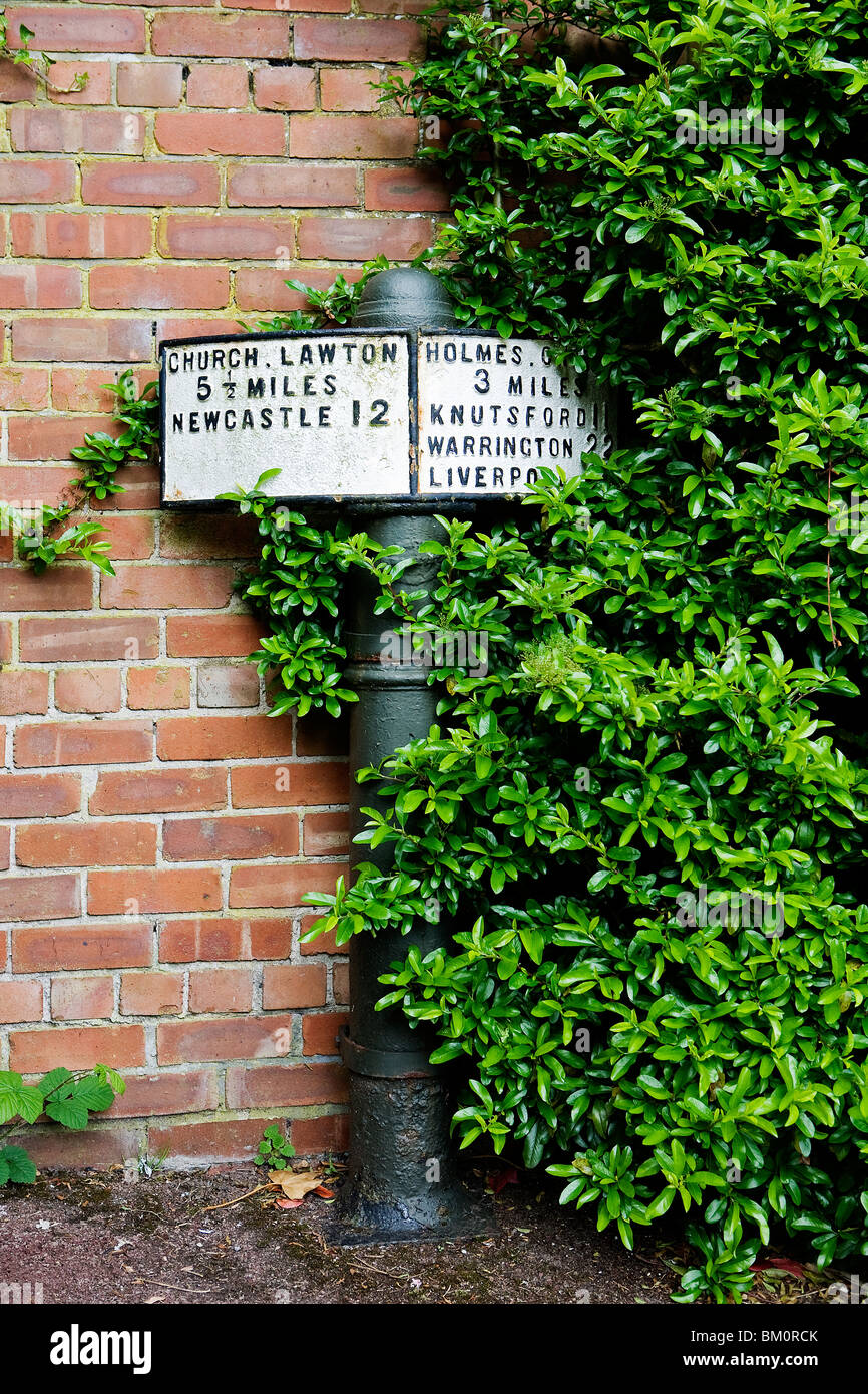 A old milepost in a precinct in Knutsford Town centre Stock Photo