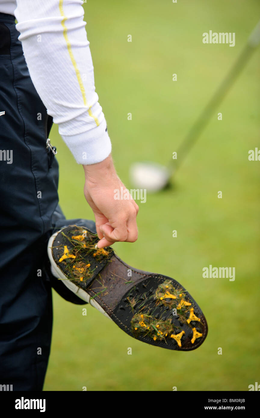 A golfer uses a tee to clean wet grass from his spikes at the Celtic Manor Wales Open 2008 May 2008 Stock Photo