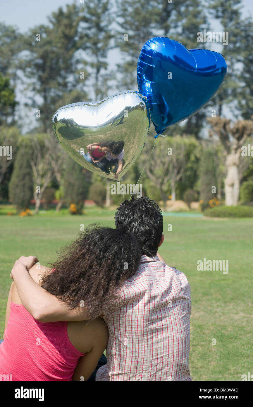 Couple with balloons in a park Stock Photo - Alamy