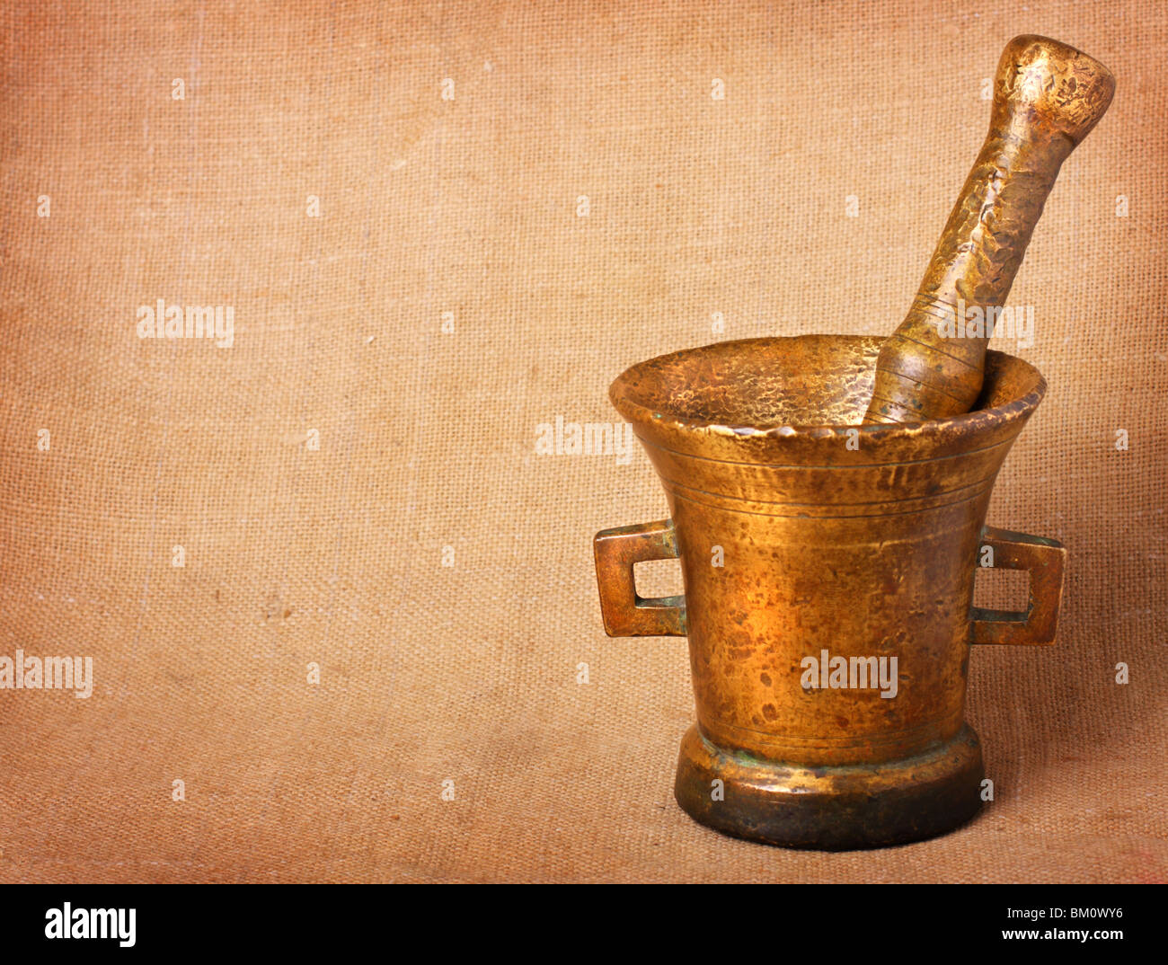 Old bronze mortar and pestle on sacking background Stock Photo - Alamy