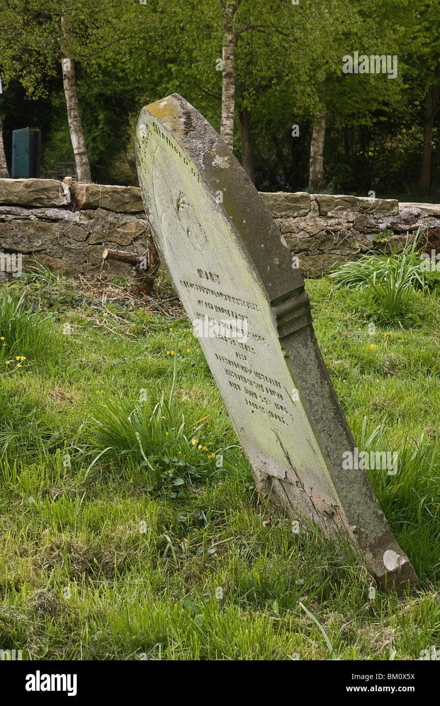 Old grave stone leaning at a precarious angle. Stock Photo