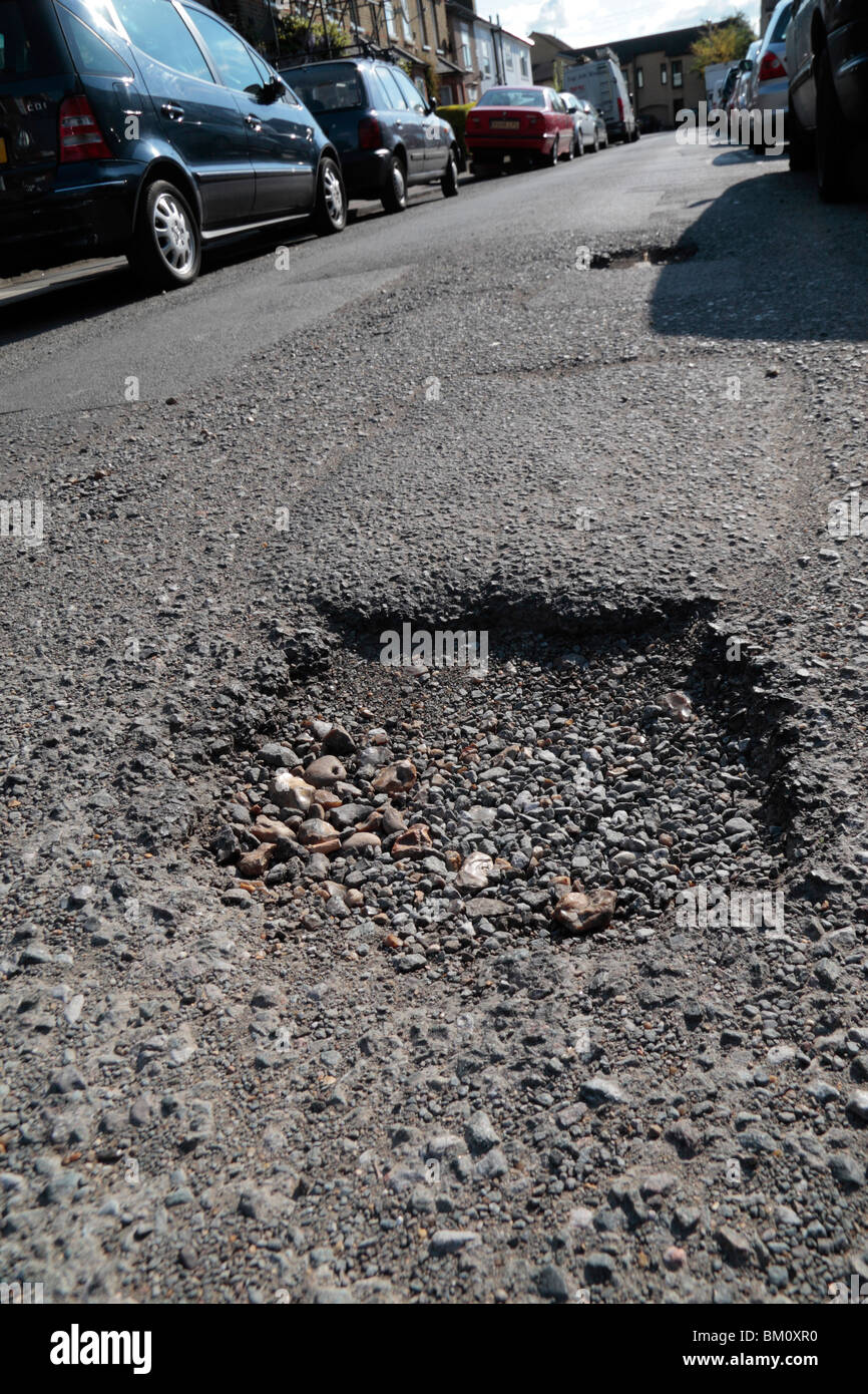 Close up of a pot hole in a suburban road in Hounslow, Middx, UK. May 2010  See BM0R6P for repaired road. Stock Photo