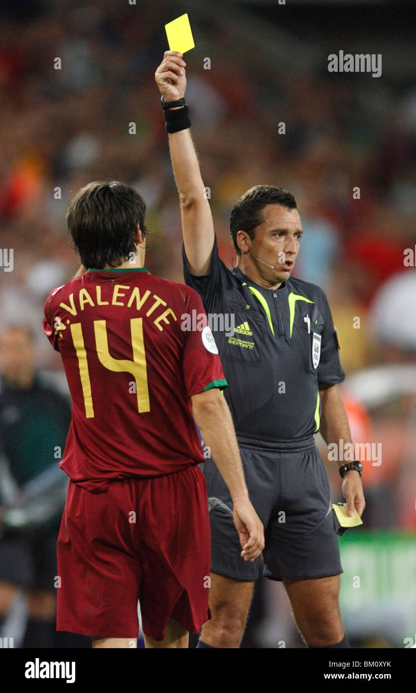 Nuno Valente of Portugal (l) receives a yellow card caution from referee Jorge Larrionda during a 2006 World Cup soccer match. Stock Photo