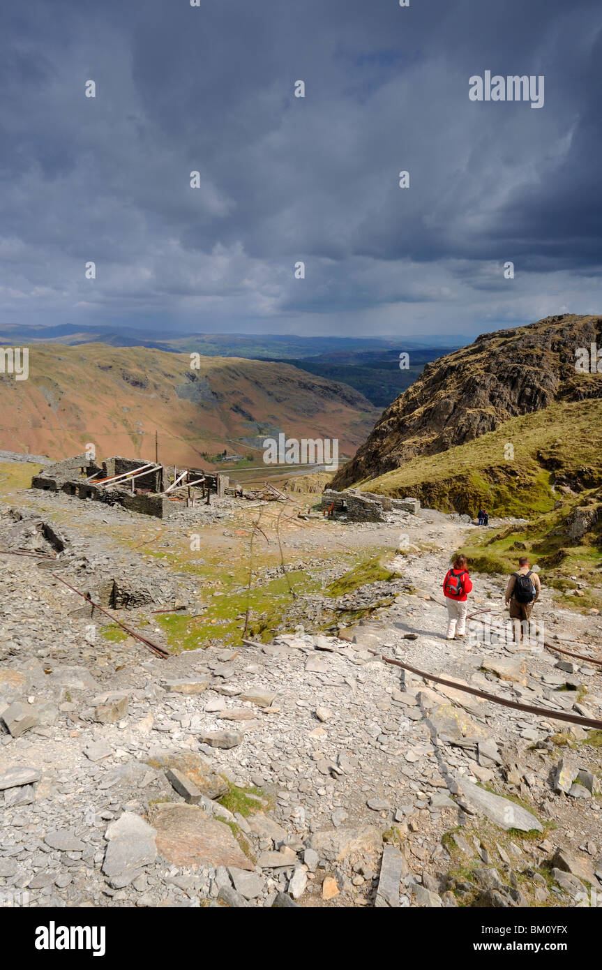 Walkers descending the Old Man of Coniston past the old slate workings in the Lake District Stock Photo