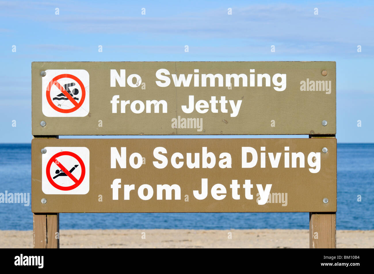 No swimming or scuba diving from jetty signs made of wood at a beach in Sandwich, Cape Cod USA Stock Photo