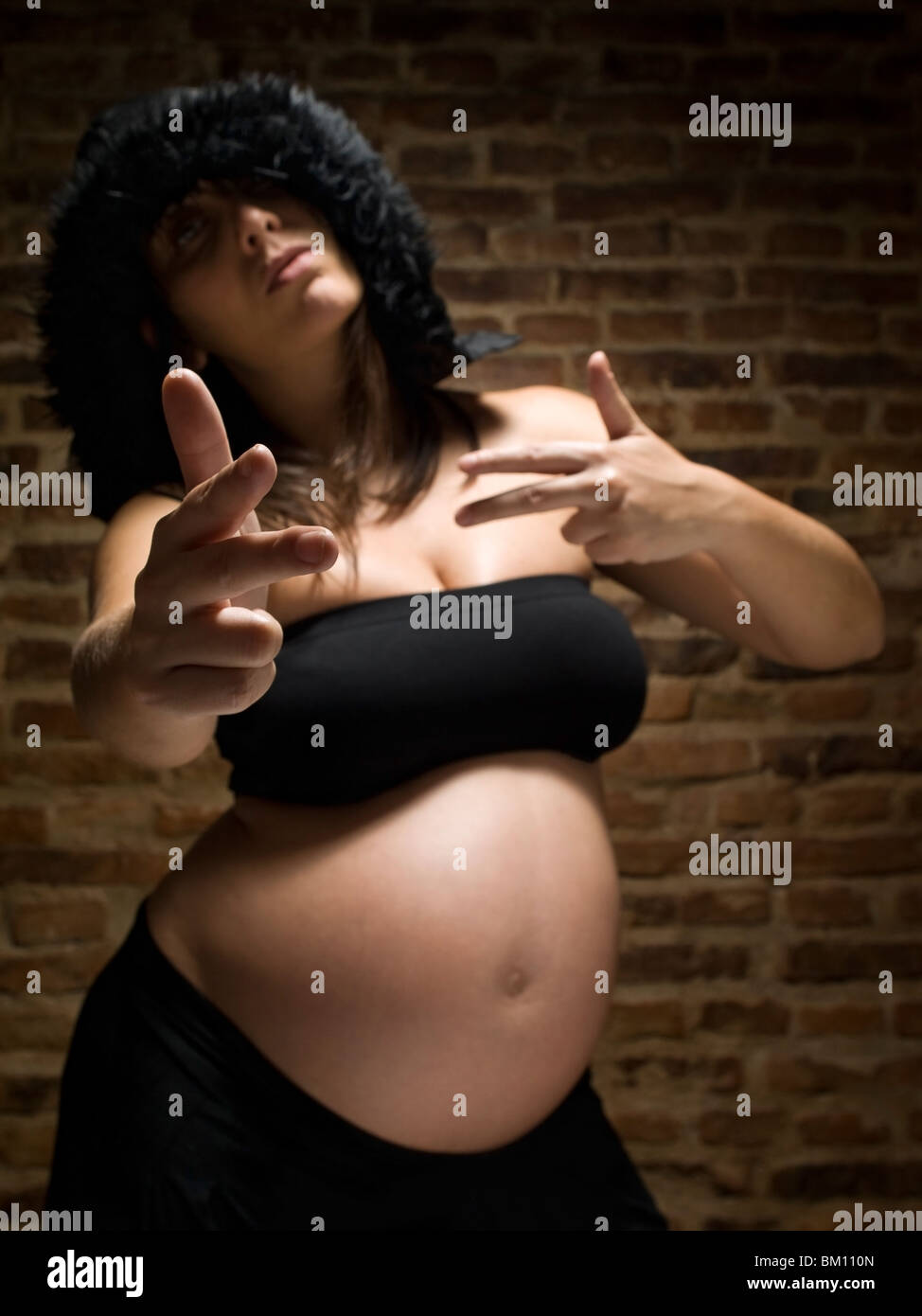 A young pregnant woman gesturing as she was armed. Focus on the hand. Stock Photo