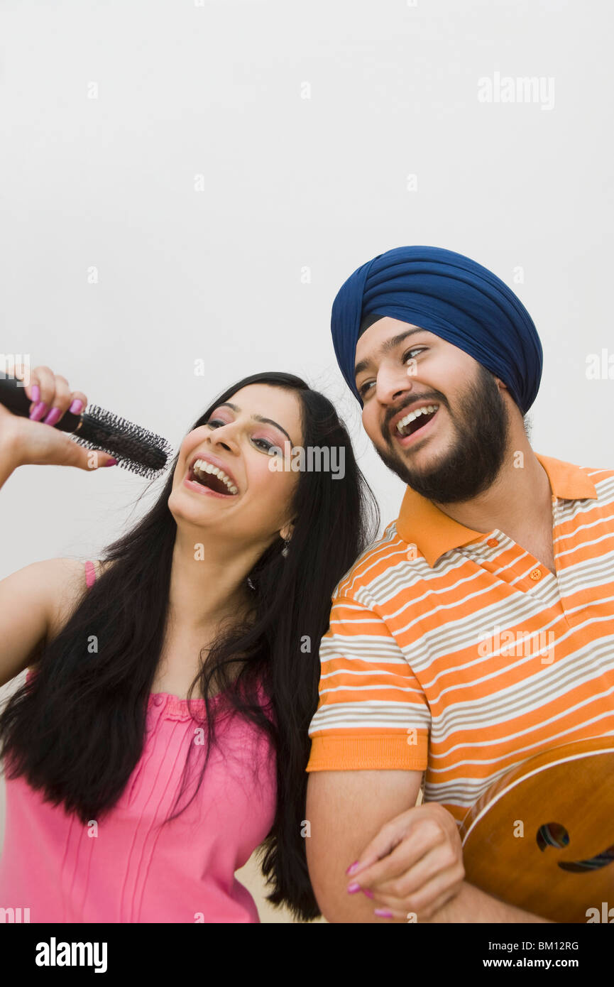 Man playing guitar and his wife singing Stock Photo