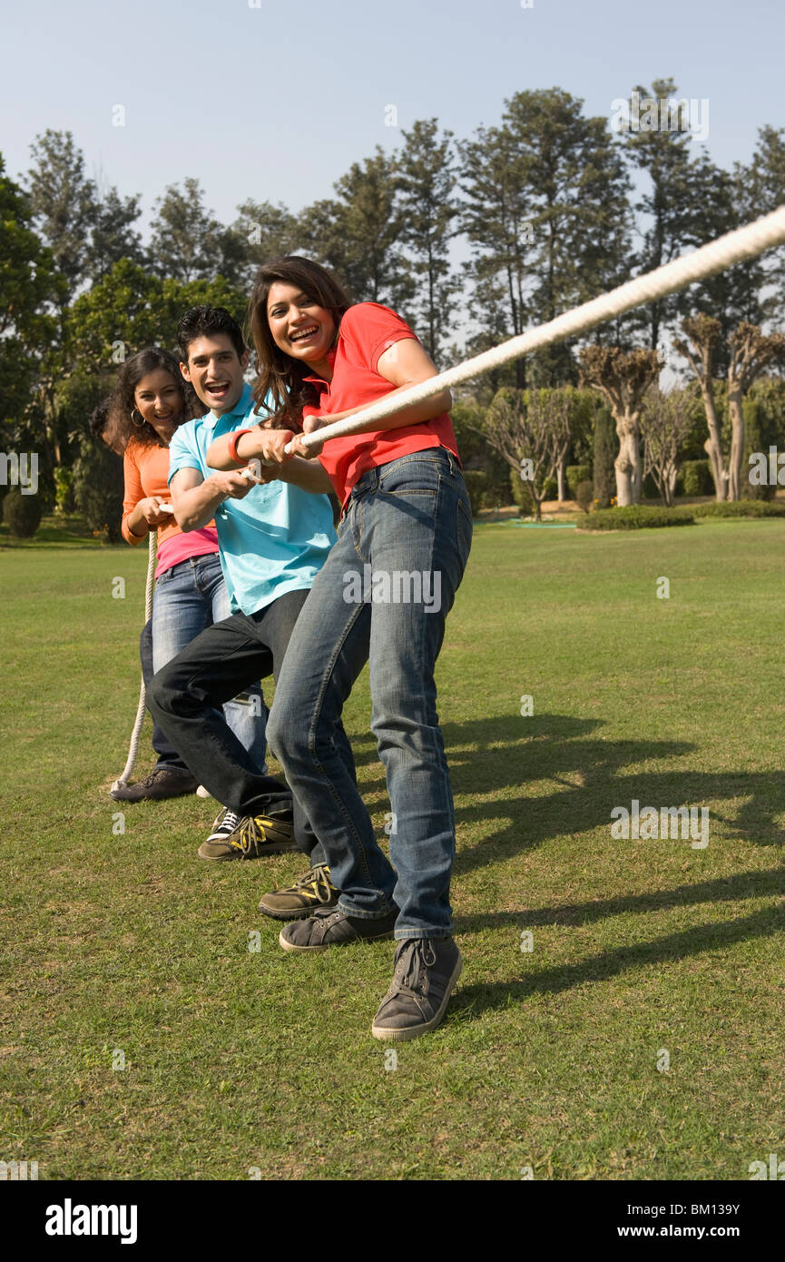 Friends pulling rope in a park Stock Photo Alamy