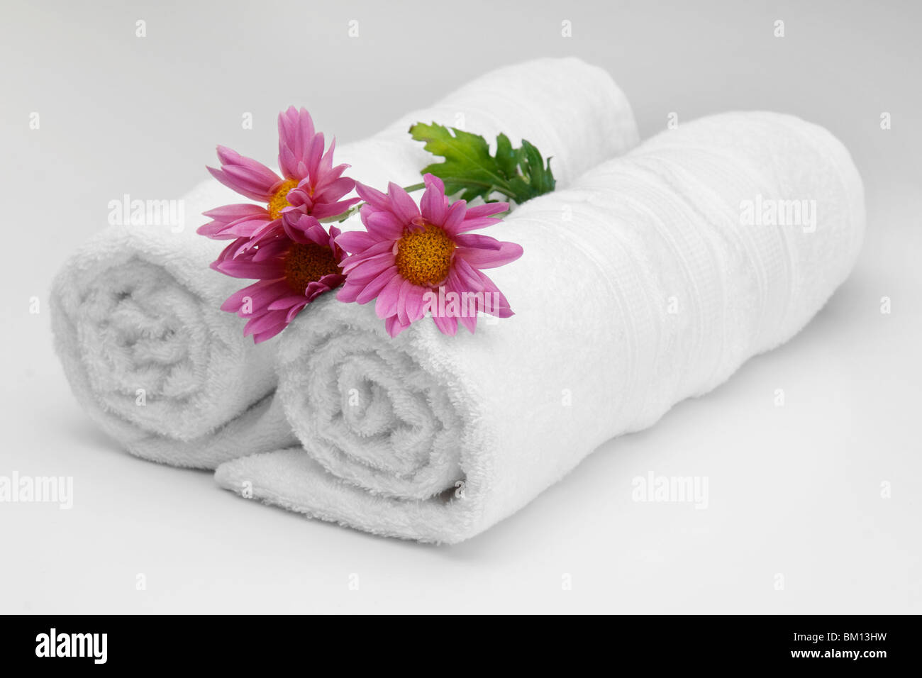 https://c8.alamy.com/comp/BM13HW/close-up-of-rolled-up-towels-with-flowers-BM13HW.jpg