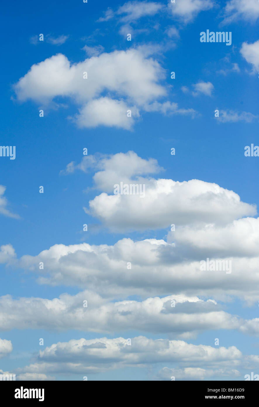Fluffy white clouds in a bright blue sky Stock Photo - Alamy