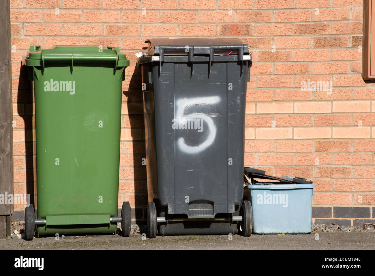 Wheelie bins and recycling boxes waiting for collection on a housing