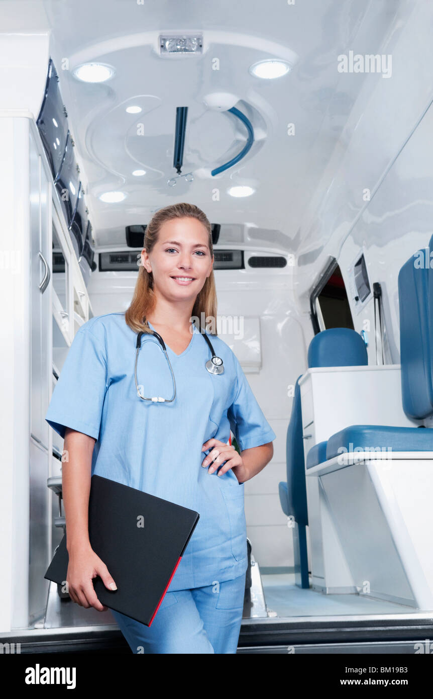 Female nurse standing in front of an ambulance Stock Photo