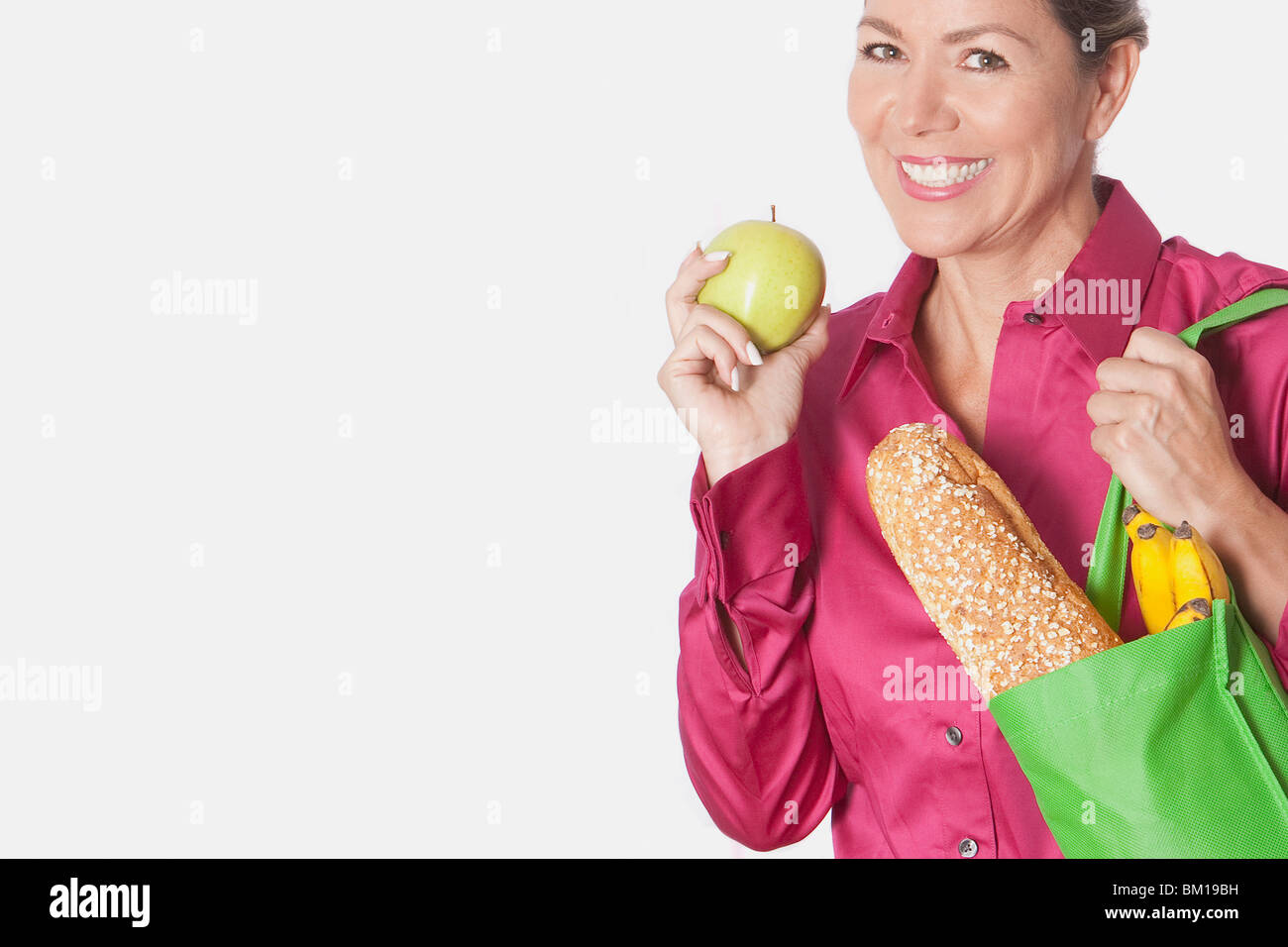 Woman holding a shopping bag of groceries with fruits Stock Photo