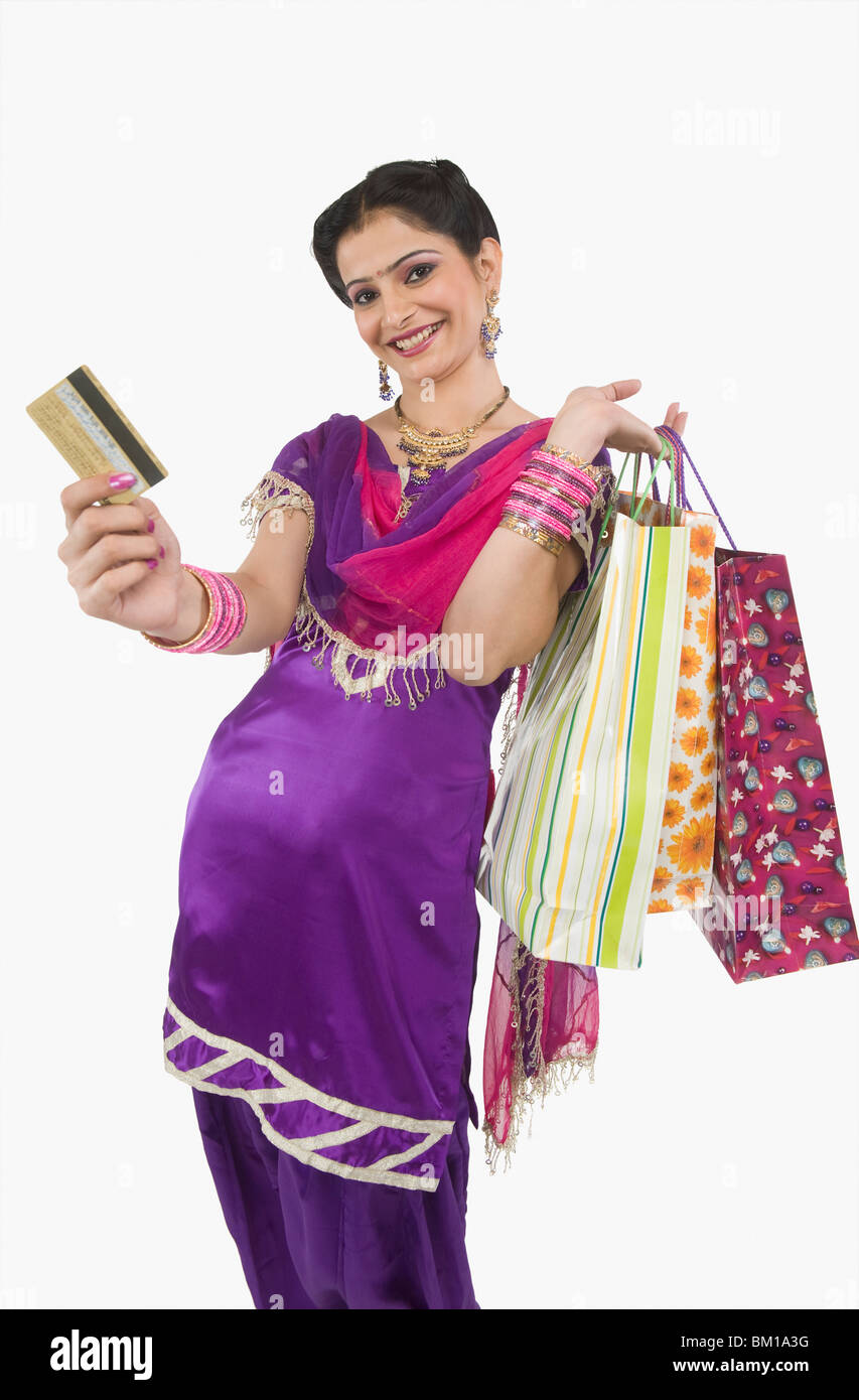 Woman carrying shopping bags and showing a credit card Stock Photo